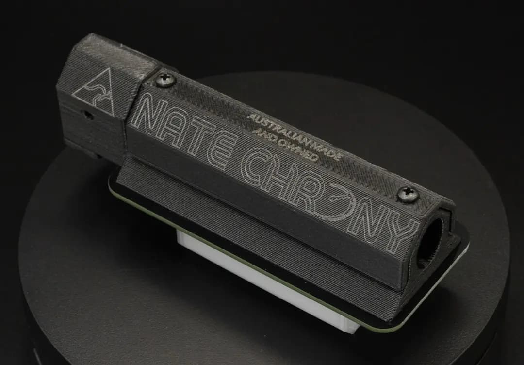 Close-up of the NateChrony device, featuring a sleek black design with engraved branding and ‘Australian Made and Owned’ text, displayed on a dark background, highlighting its precision and craftsmanship.